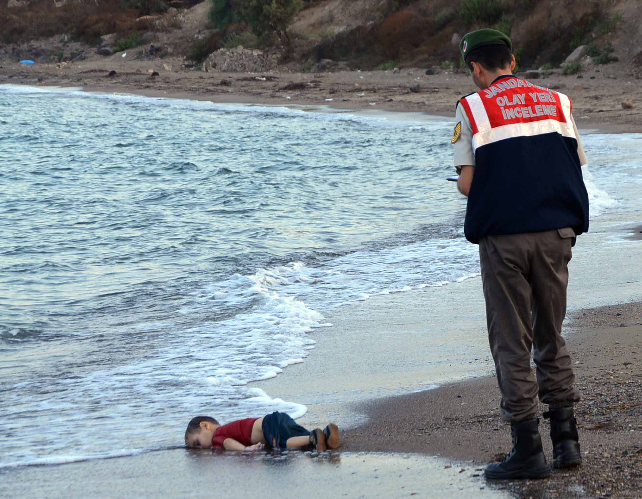 2015年9月2日,叙利亚三岁男孩 Aylan Kurdi 于地中海溺亡后,伏尸土耳其海滩。 照片成为全球新闻的头条,促使国际认真应对难民危机,欧洲国家暂时对难民采取较开放态度。摄:Nilufer Demir/DHA via AP/达志影像