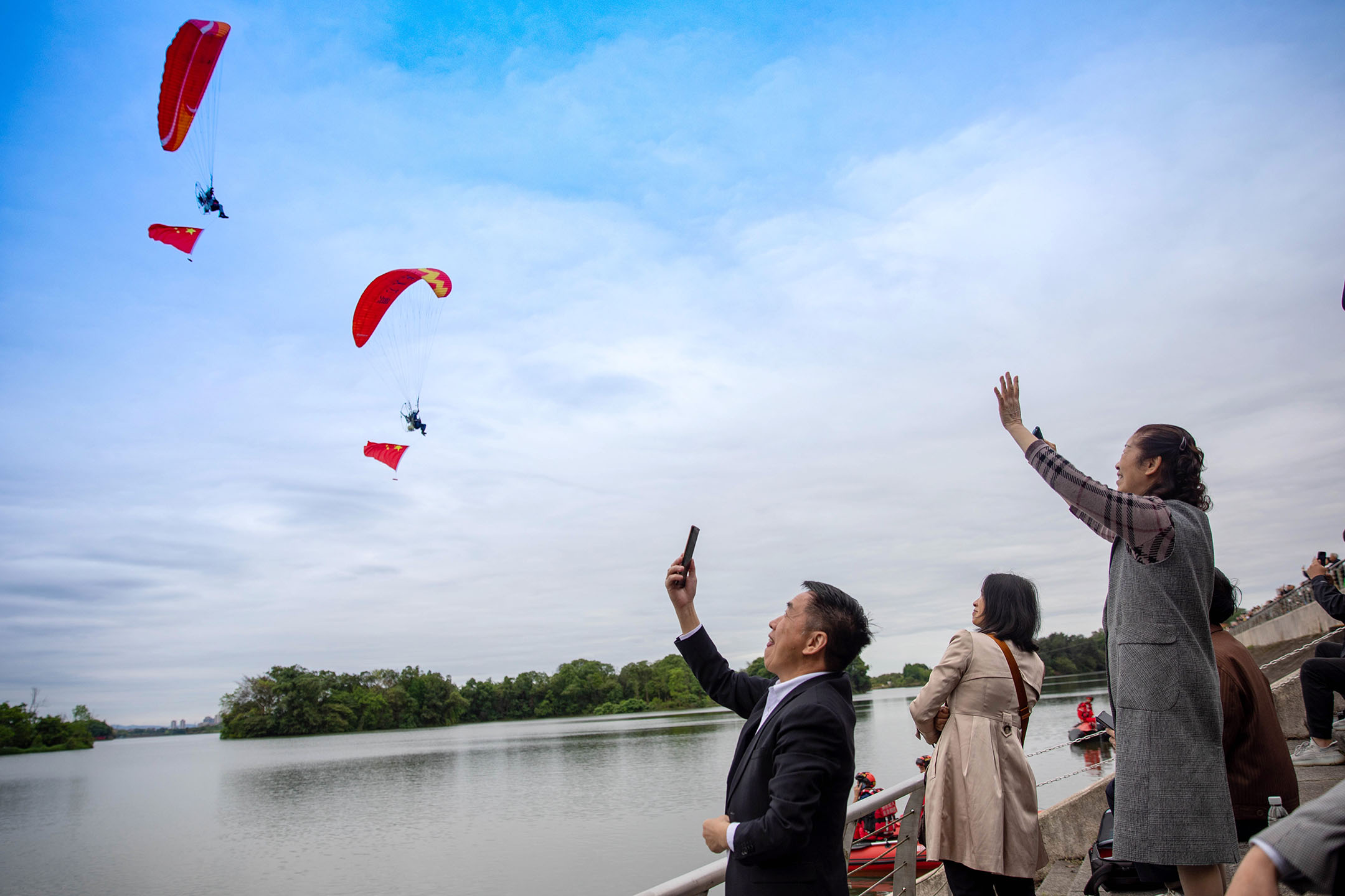 2024年4月30日,中国重庆举行低空飞行消费周,人们在龙水湖附近观赏低空飞行表演。摄:Huang Shu/VCG via Getty Images