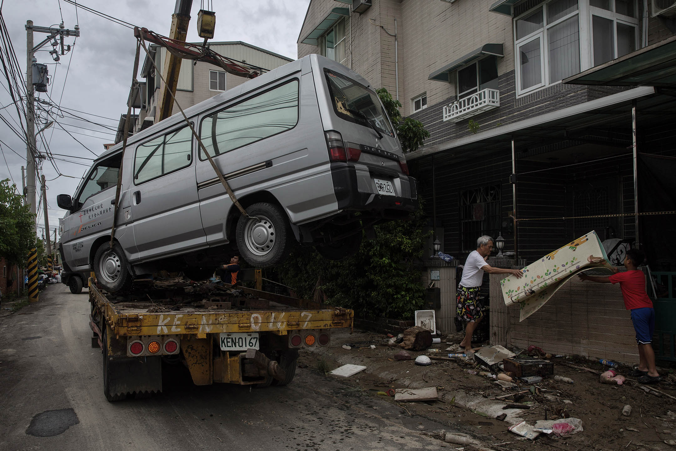 2024年7月27日,嘉義水上鄉,居民在移動一架在風災中毀壞的車。攝:陳焯煇/端傳媒