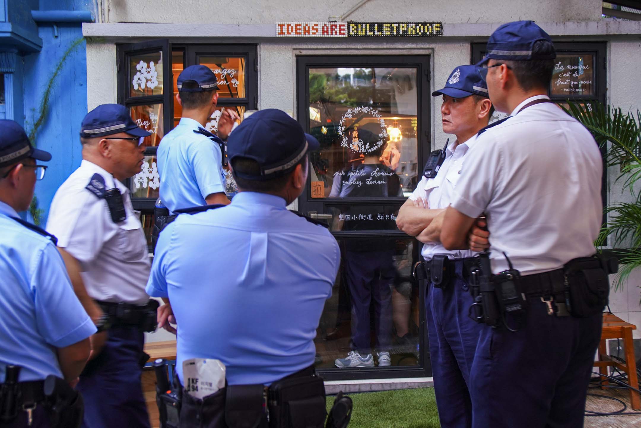 2024年6月30日,香港见山书店,警方最终来了至少三部警车、六名白衣督察、数以十计的军装警察,还有若干便衣随行。摄影:萧云