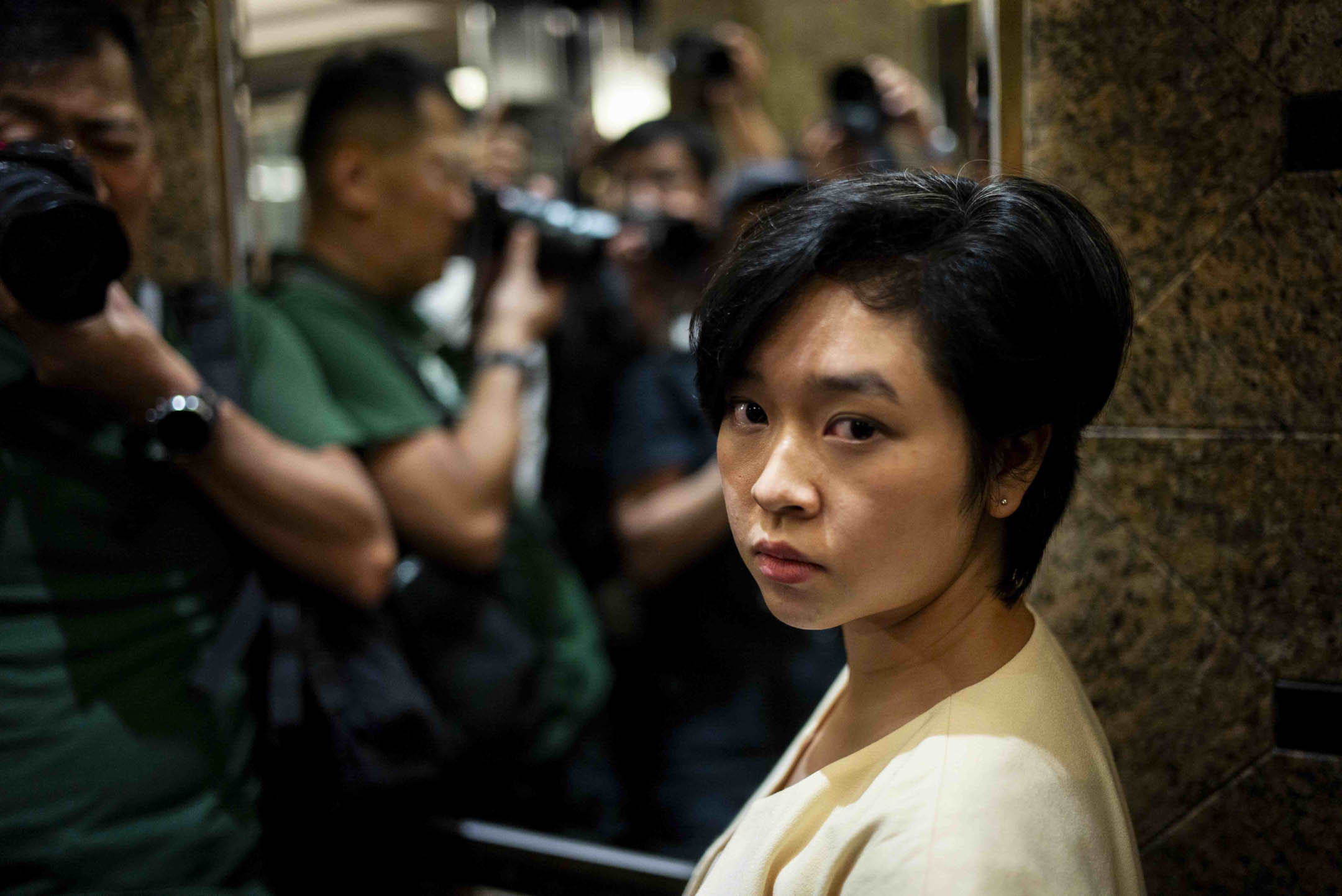 2024年7月17日,香港記者協會主席鄭嘉如遭《華爾街日報》辭退後,離開中環廣場的辦公室,被大批傳媒追訪。攝:林振東/端傳媒