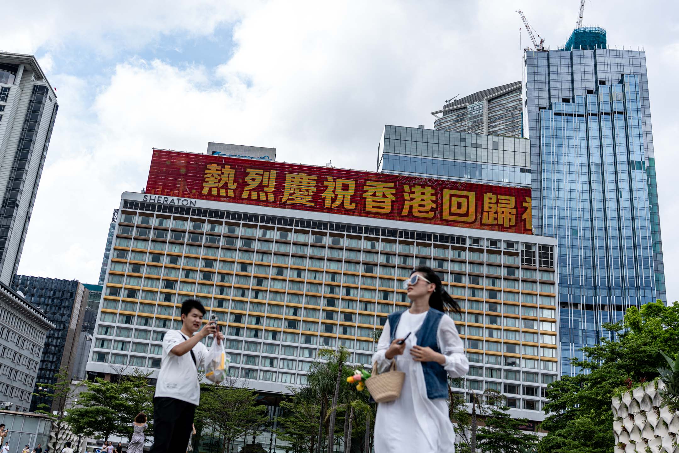 2024年7月1日，尖沙咀，有大廈顯示屏上寫有慶祝回歸27周年的字句。攝：Ryan Lai/端傳媒