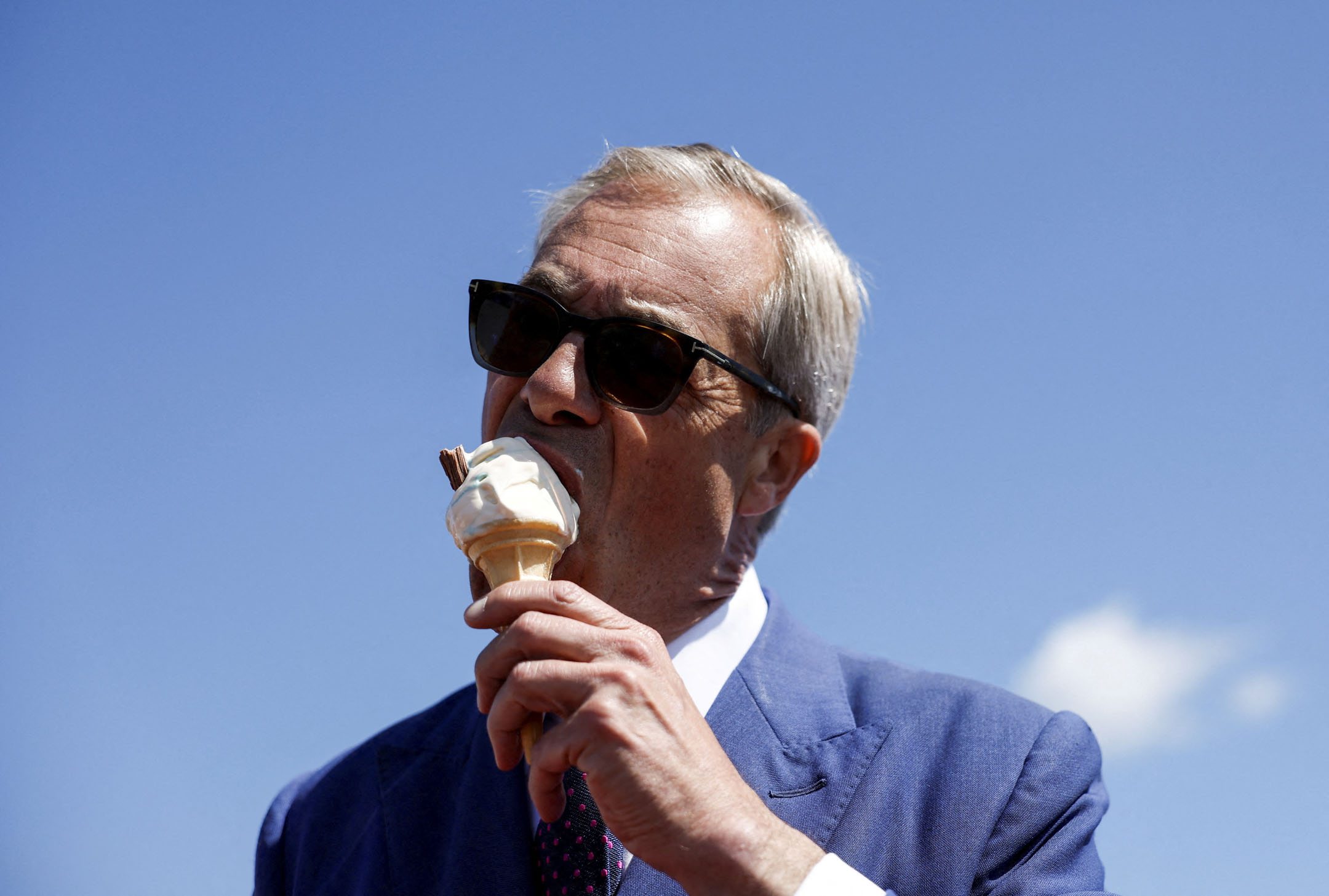 2024年7月4日,英國改革黨黨魁兼創辦人Nigel Farage 在濱海克拉克頓的大選當天吃雪糕。攝:Clodagh Kilcoyne/Reuters/達志影像