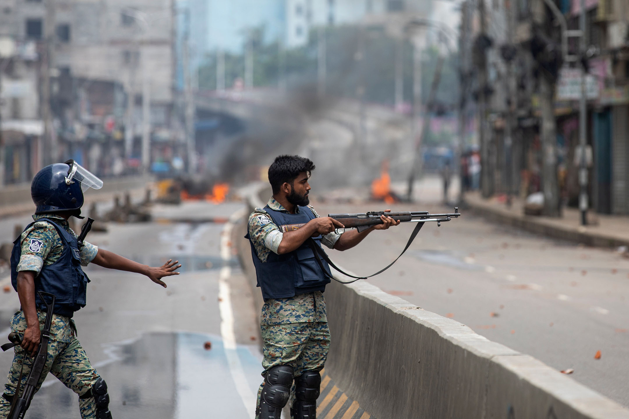 2024年8月5日,孟加拉,一名警察將武器瞄準示威者。攝:Rajib Dhar/AP/達志影像