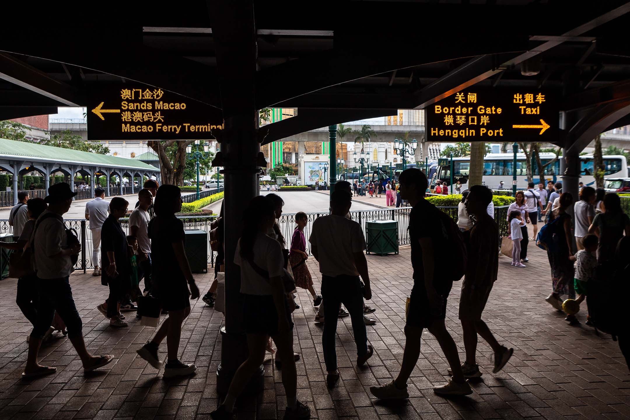 2023年8月24日,澳門,人們在賭場度假村的巴士總站前經過。攝:Eduardo Leal/Bloomberg via Getty Images