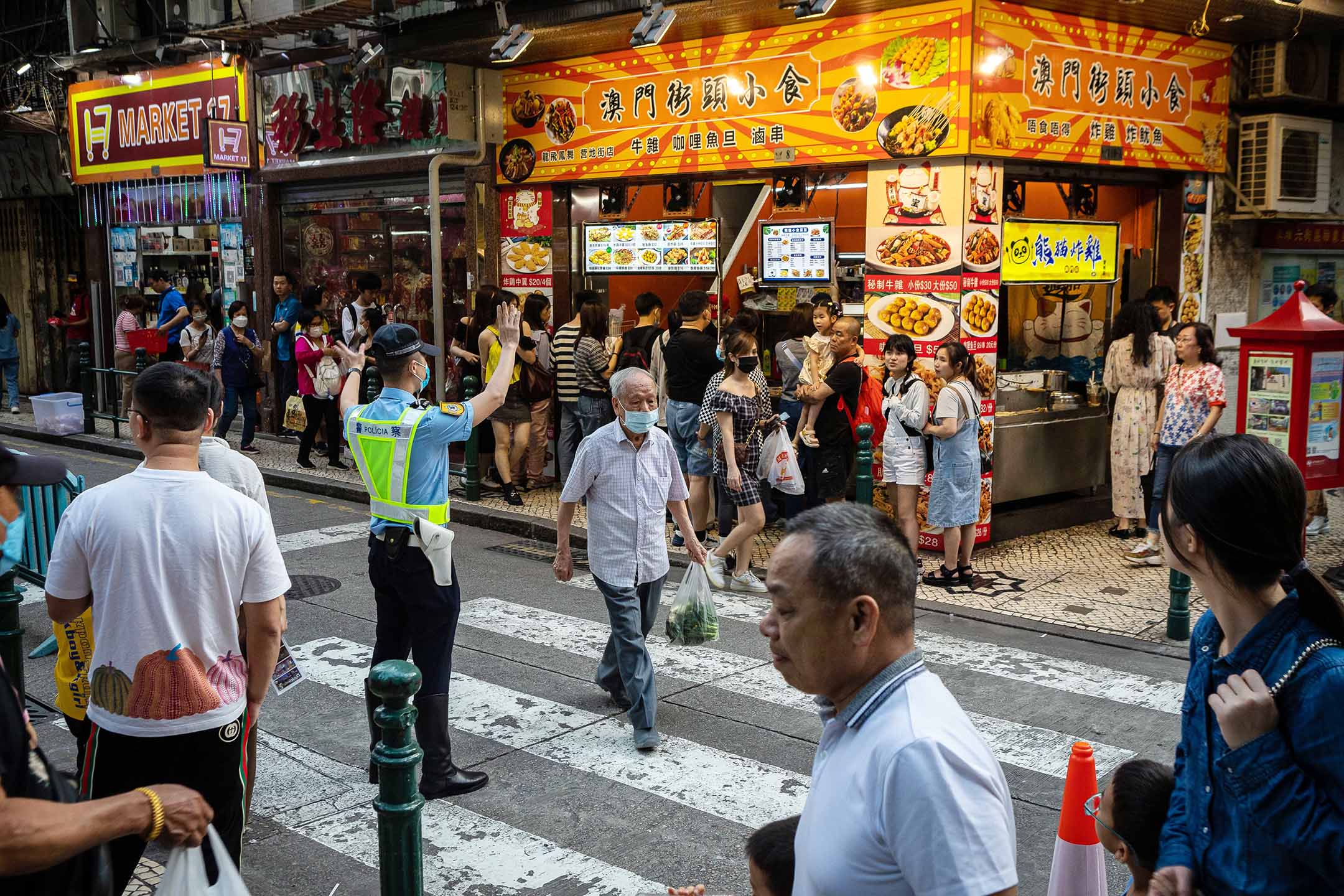 2023年4月30日, 澳門,行人在街道上過馬路。攝:Eduardo Leal/Bloomberg via Getty Images
