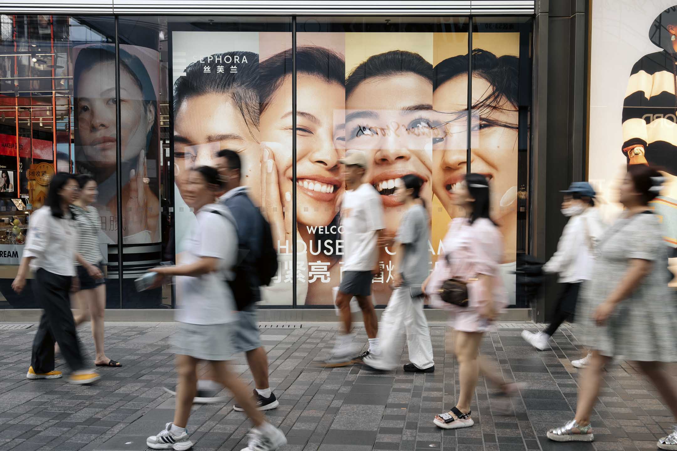 2024年8月22日,中国北京,行人经过 LVMH 集团经营的丝芙兰(Sephora) 专卖店广告。摄:Na Bian/Bloomberg via Getty Images