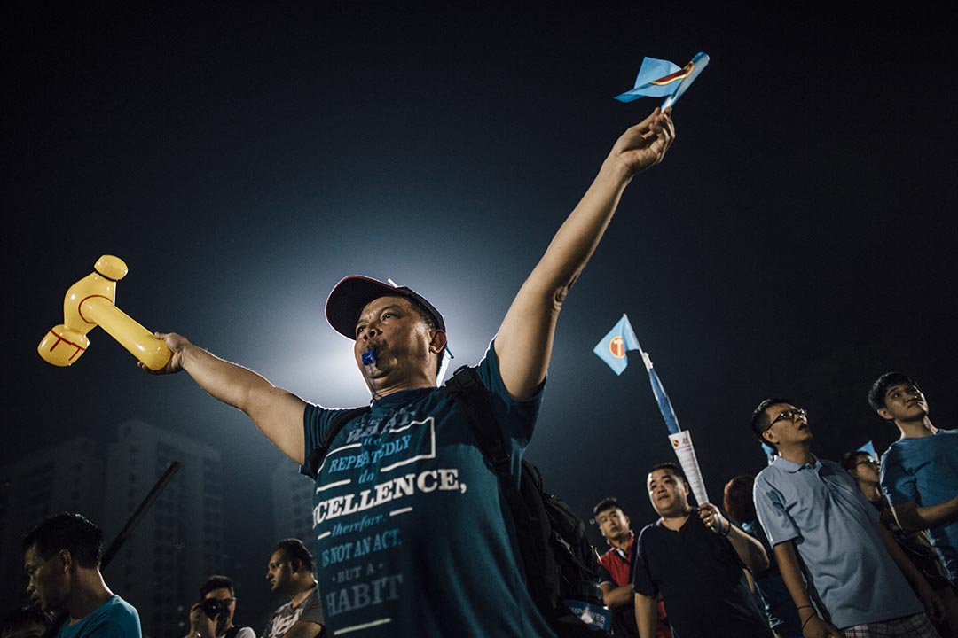 工人黨支持者口吹哨子、手舉「鎚子旗」和打氣棒。攝 : Anthony Kwan/端傳媒
