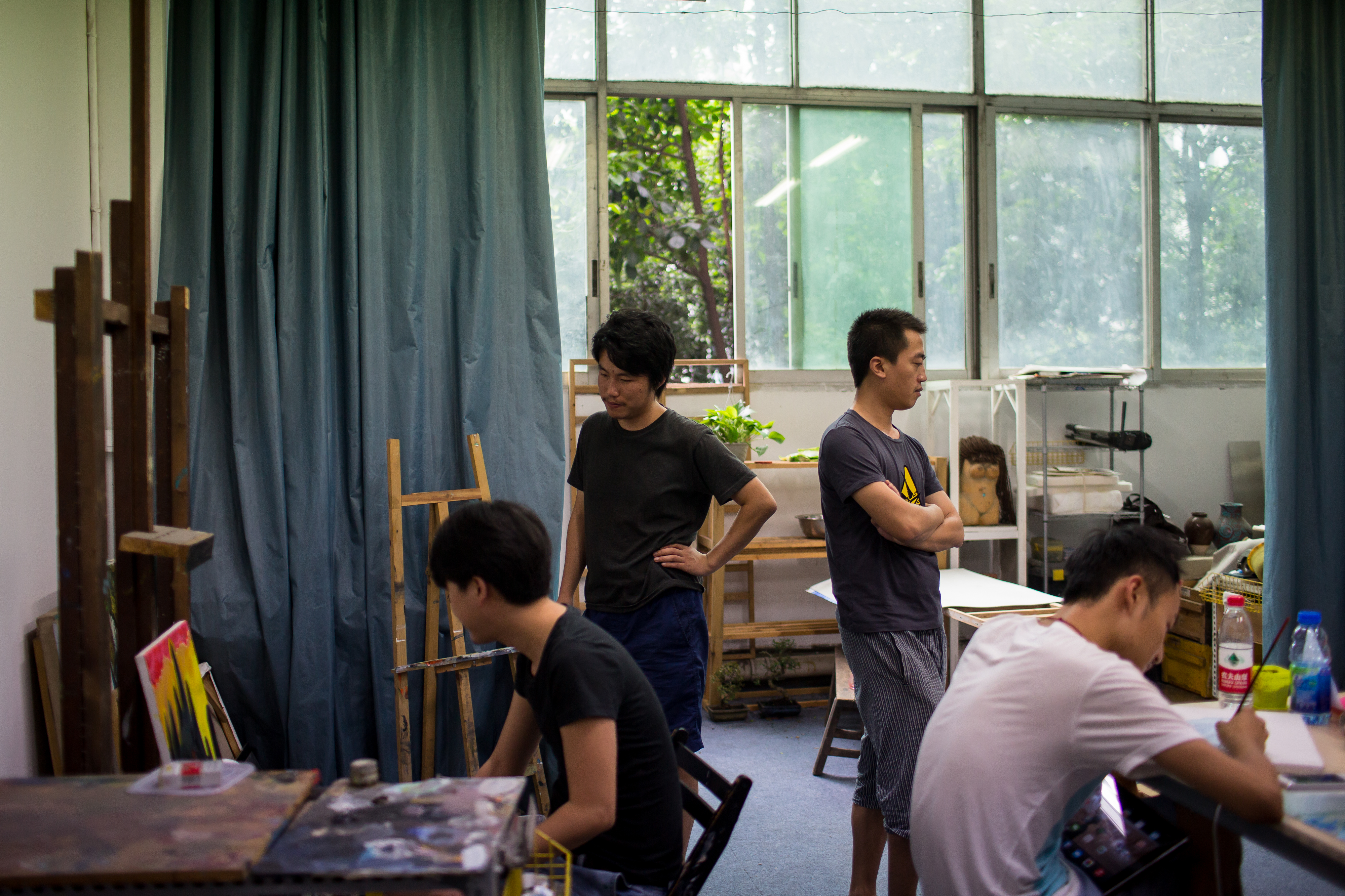 劉偉偉(左二)在朋友的油畫工作室。攝: Billy H.C. Kwok/ 端傳媒