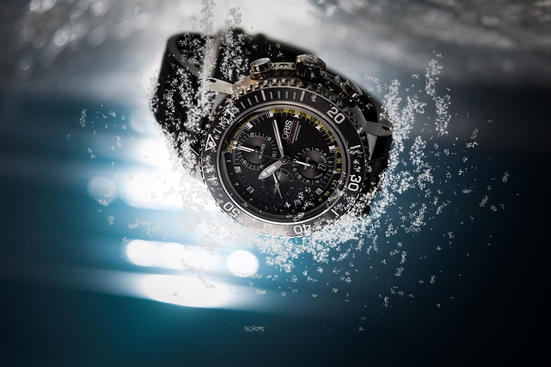 Oris Aquis Depth Chronograph :
12 時位置設有 1 個小孔,並在藍寶石水晶玻璃外緣嵌入一條小管,潛水員下潛時,管道內的空氣壓縮讓水可通過小孔進入管道。管道中的色彩變異與面盤上的黃色刻度相對應,潛水員便可清楚知道深度讀數。攝:Lit Ma/端傳媒