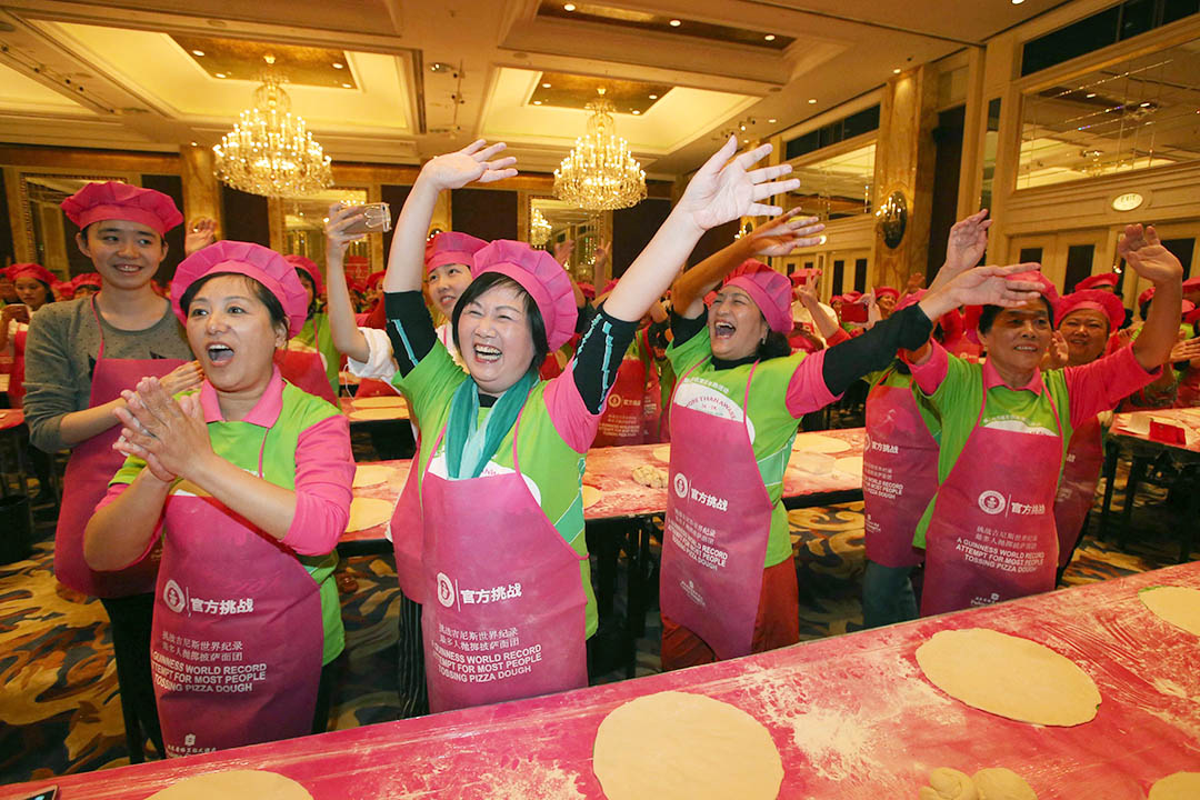 2015年10月2日,上海,511人成功打破同時最多人搓薄餅的健力氏世界紀錄(又稱吉尼斯世界紀錄),參與該挑戰的女士在場舉手慶祝。攝:CFP via GETTY