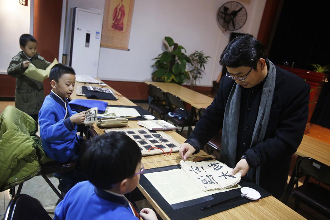 北京四海孔子書院的創辦人馮哲在論語堂看望正在練習書法的學生。攝：Wu Hao/端傳媒