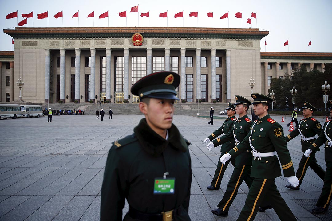 2016年3月5日,中國北京,解放軍士兵在人民大會堂前走過。攝:Damir Sagolj/REUTERS