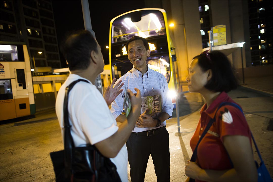 姚松炎在置富巴士总站派发选举传单,收集居民意见。摄:罗国辉/端传媒