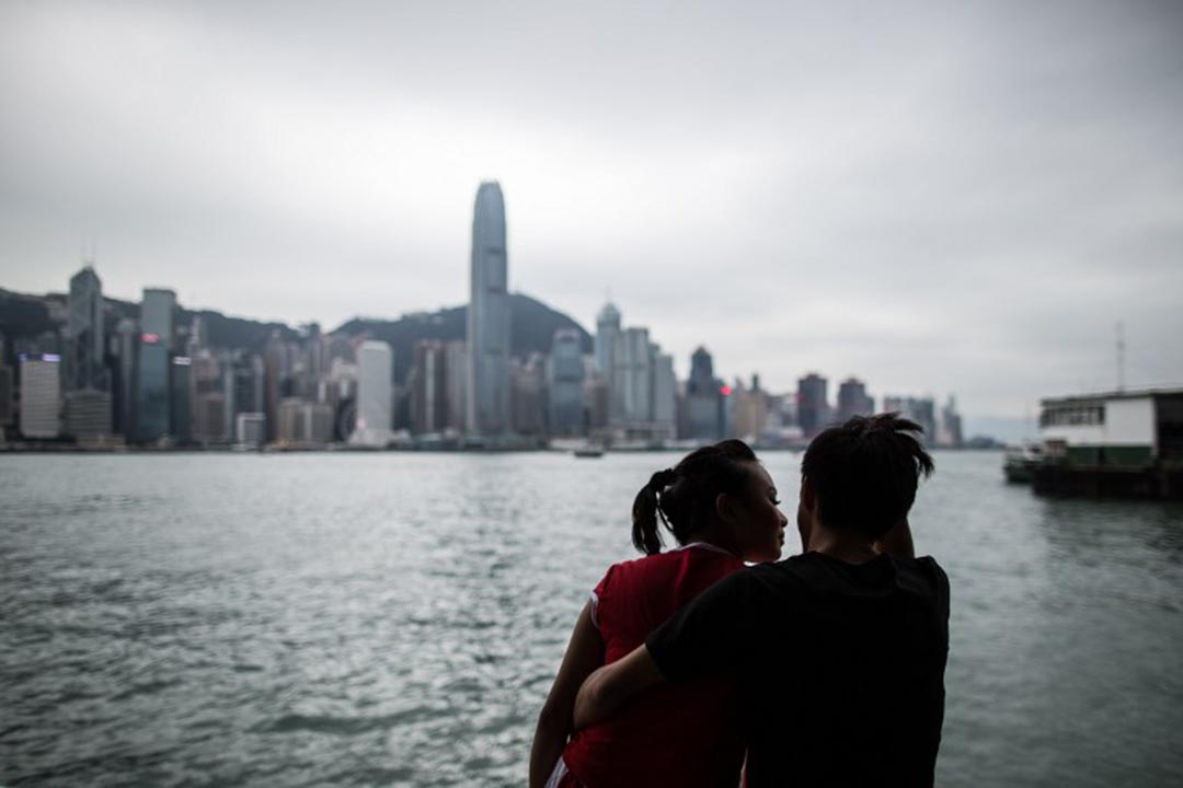 一对情侣在尖沙咀海旁谈情。摄:ANTHONY WALLACE/AFP