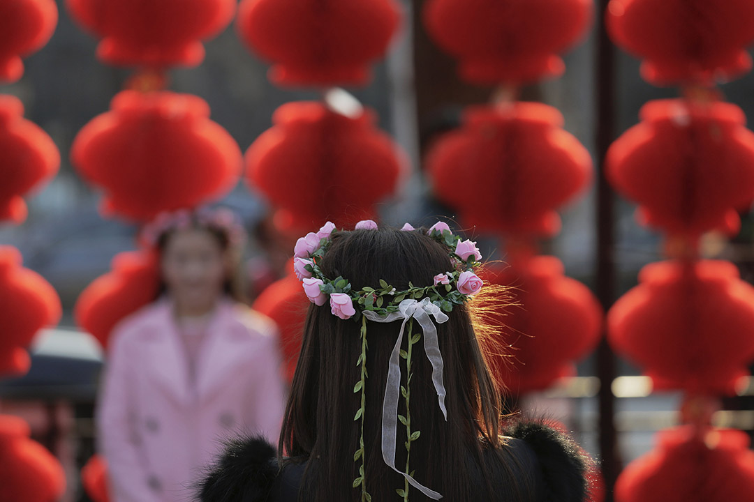 2016年2月9日,北京,一名女士在农历新年期间再龙潭公园为女友人拍照。摄:Damir Sagolj/REUTERS