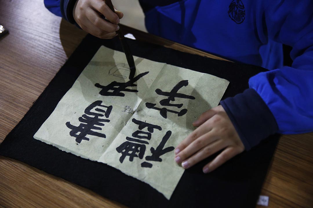 學生正在論語堂內練習書法。攝：Wu Hao/端傳媒