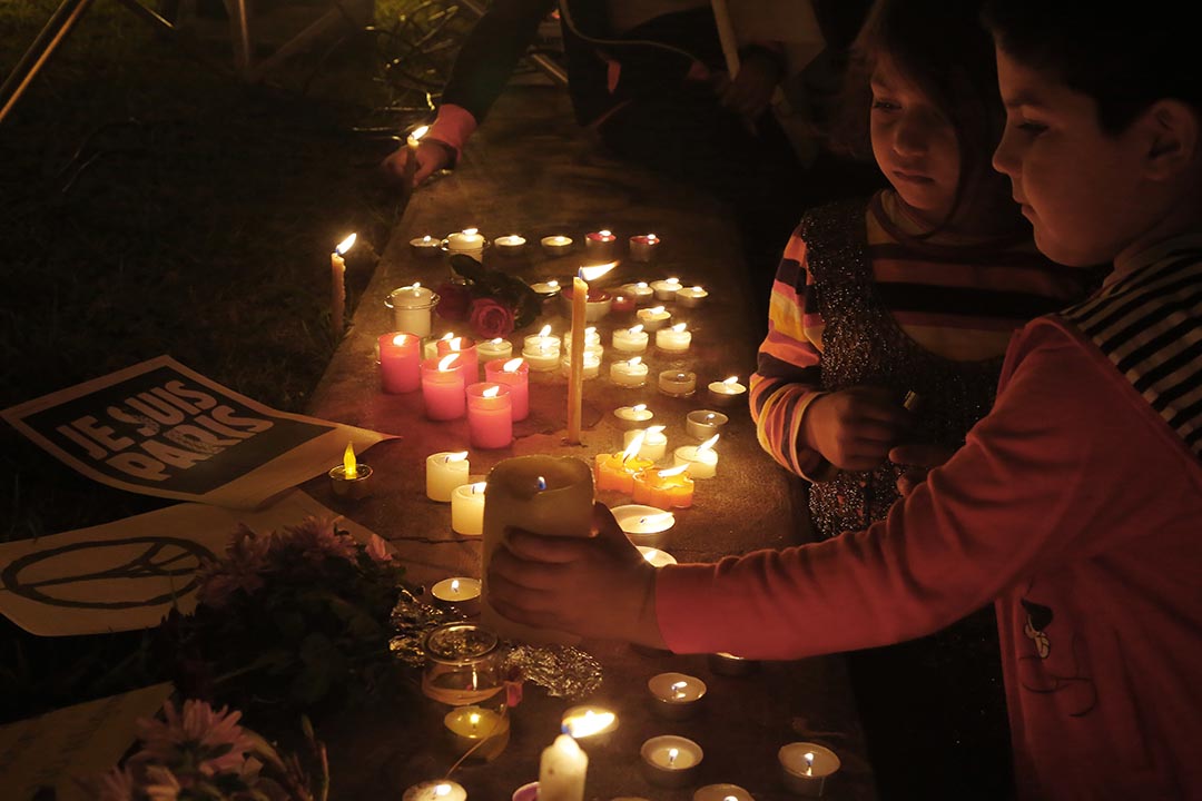 2015年11月15日,塞浦路斯,两名小孩手持烛光悼念法国枪击案死难者。摄:Petros Karadjias/AP