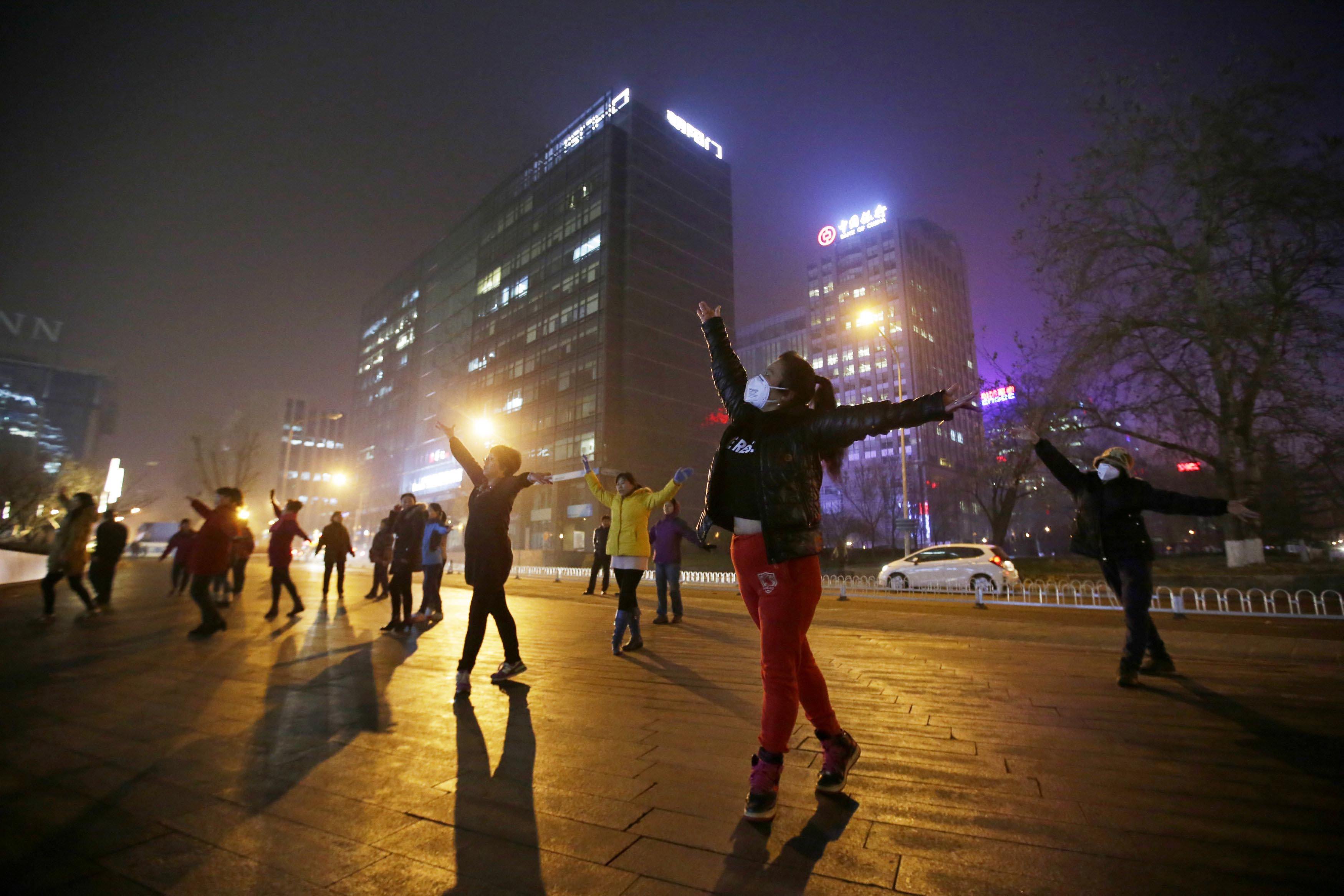 北京一个广场,大妈在雾霾天气中跳舞。摄:Jason Lee/REUTERS